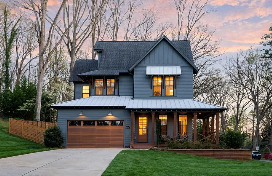 Modern farmhouse luxury home in Charlotte at sunset with dark exterior