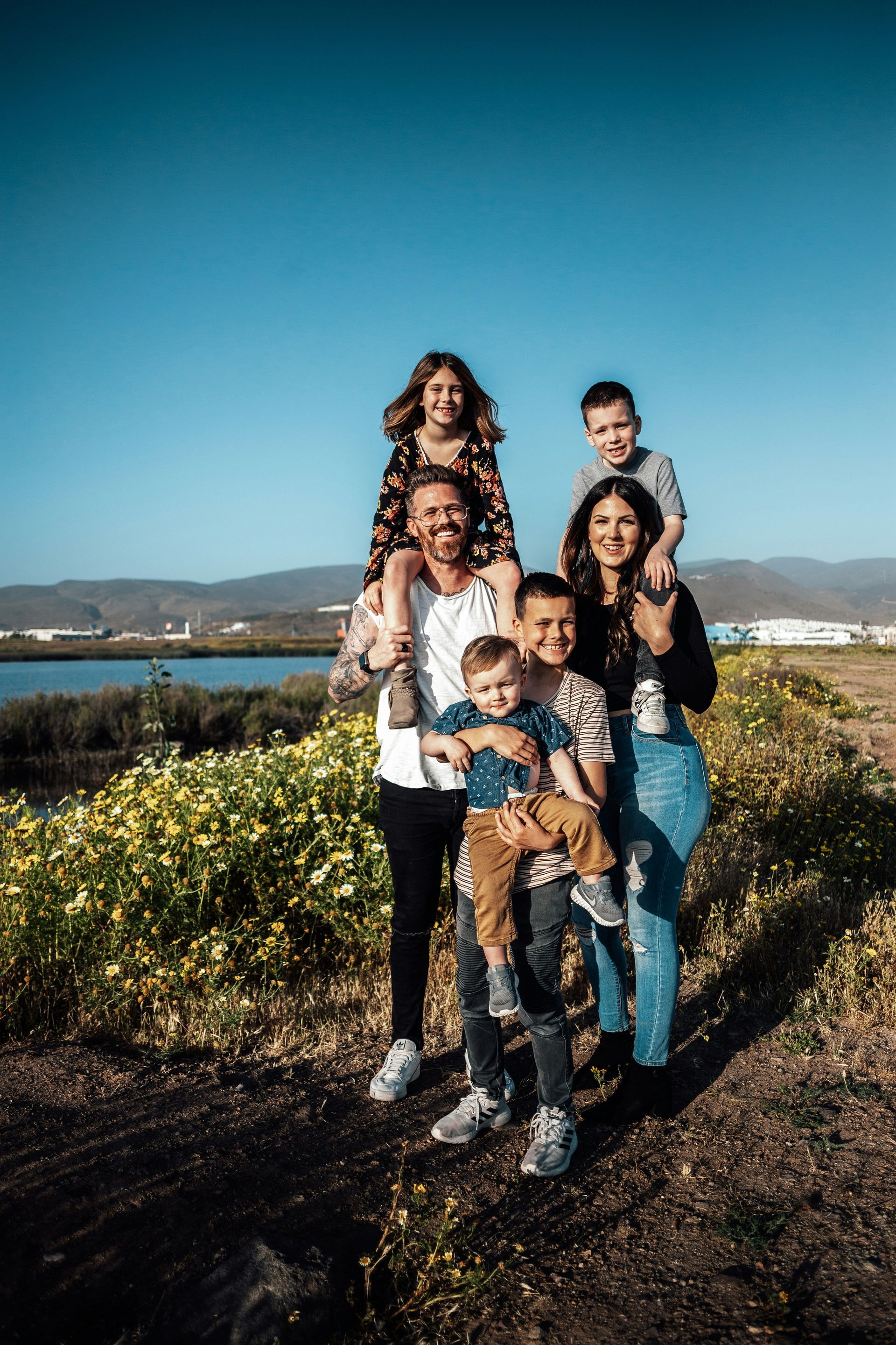 A family with personal insurance is posing for a picture in a field of flowers.