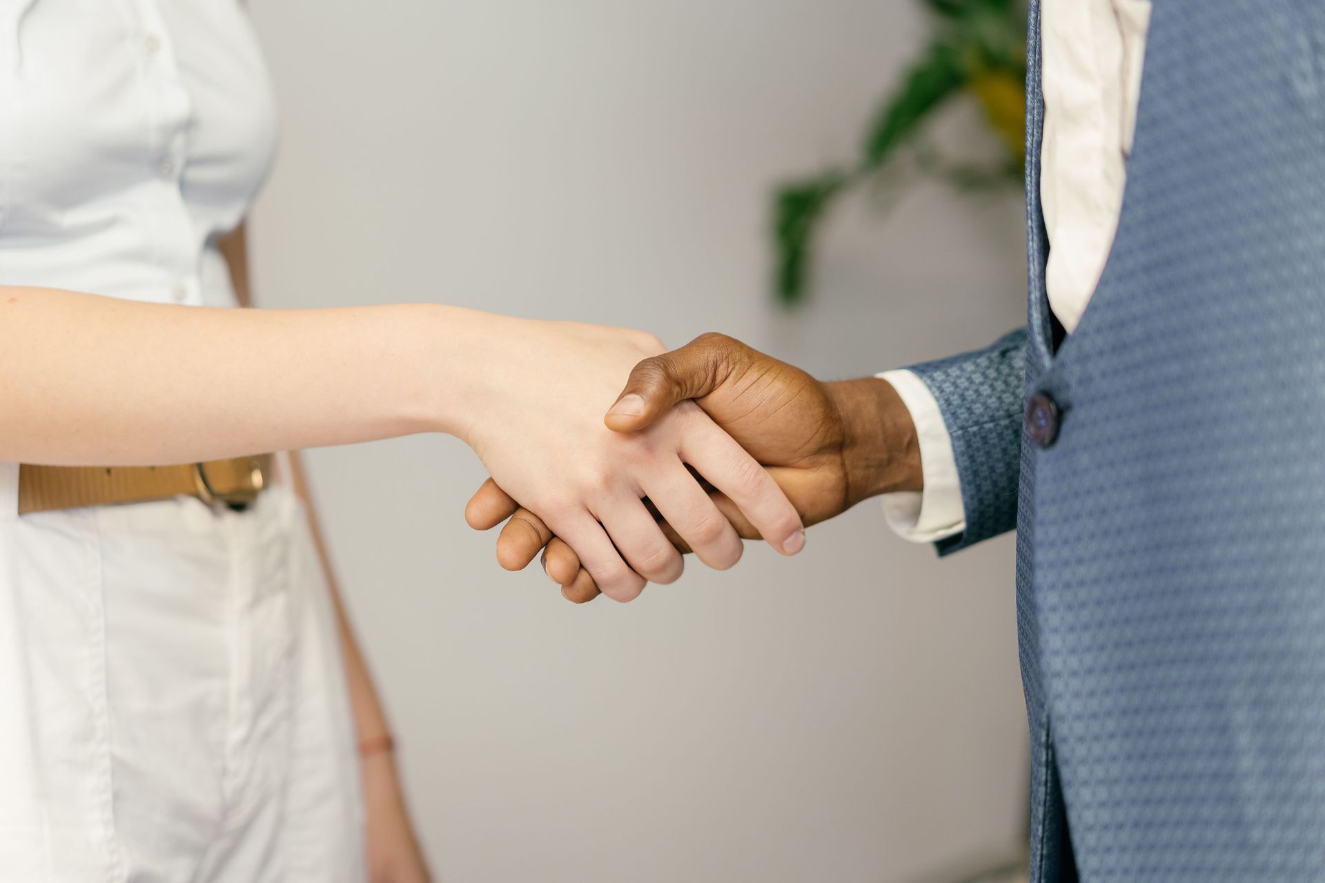 Two people shaking hands in a bright office setting