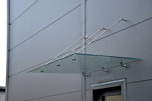 A glass canopy is attached to the side of a building.