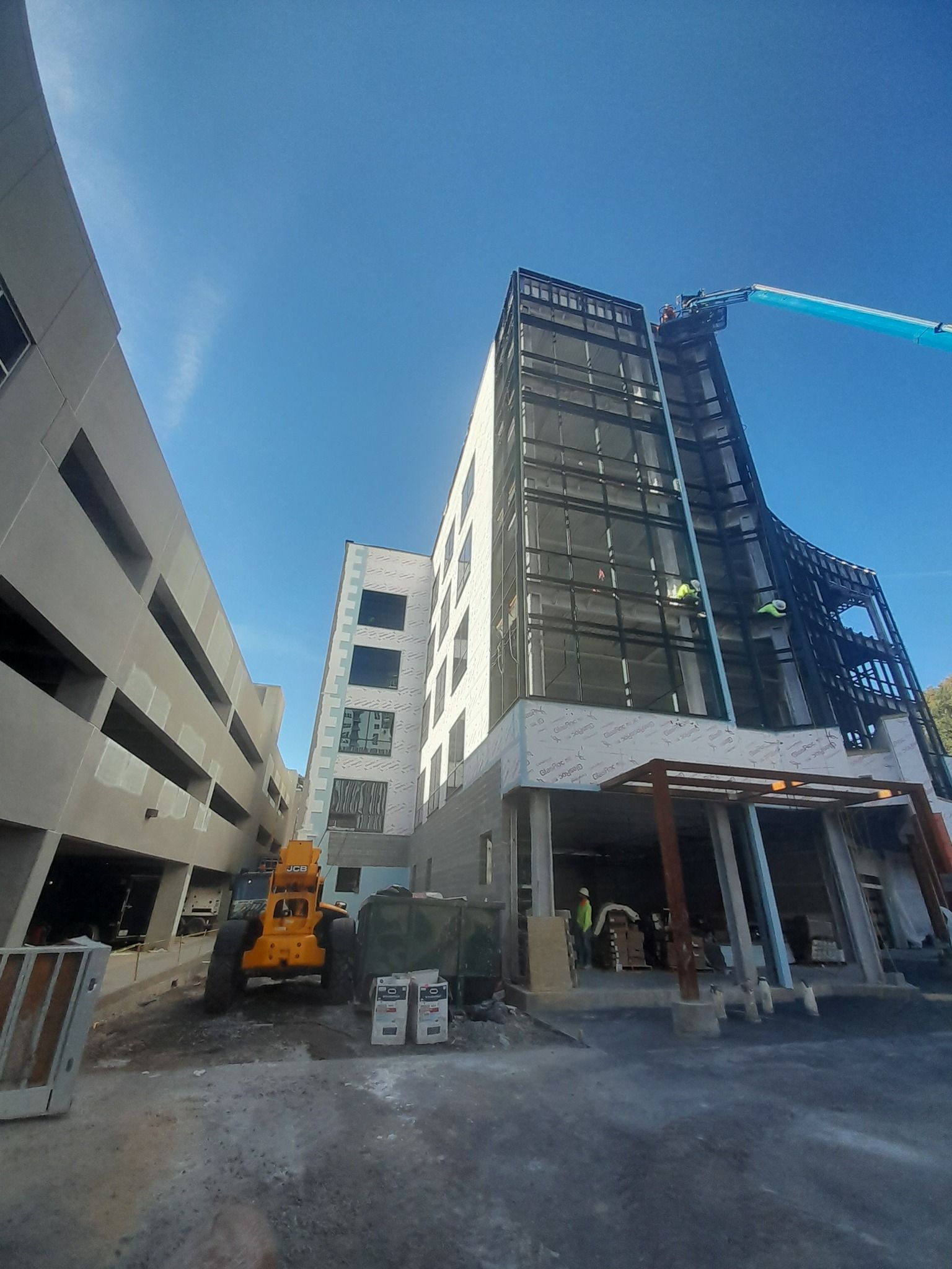 A large building is being built next to a parking garage.