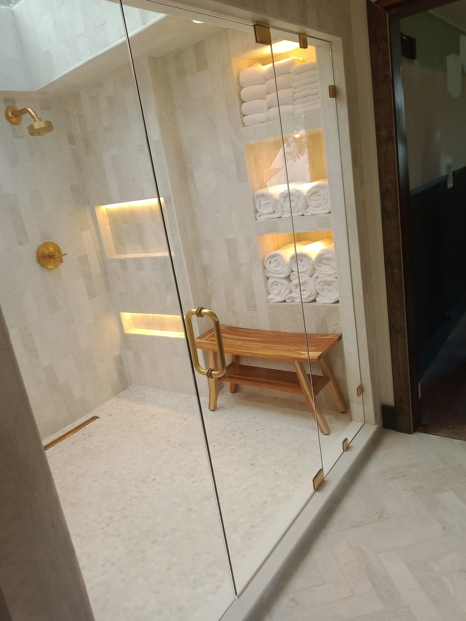 A bathroom with a walk in shower and a bench