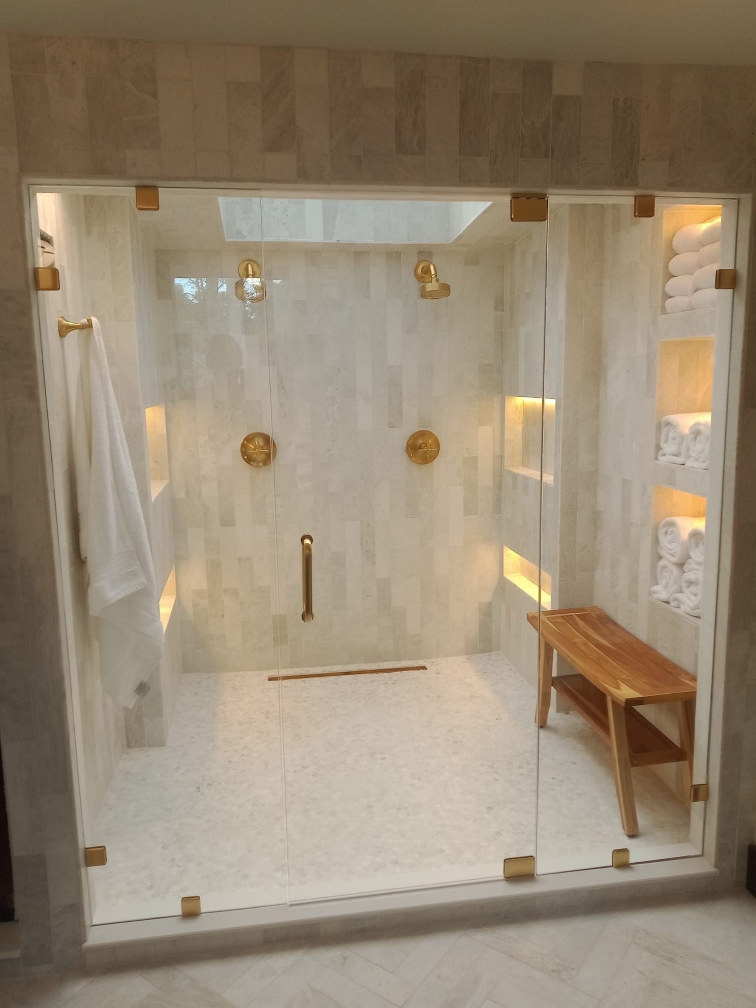 A bathroom with a walk in shower and a bench