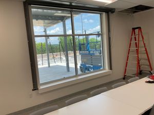 A conference room with a large window and a ladder.