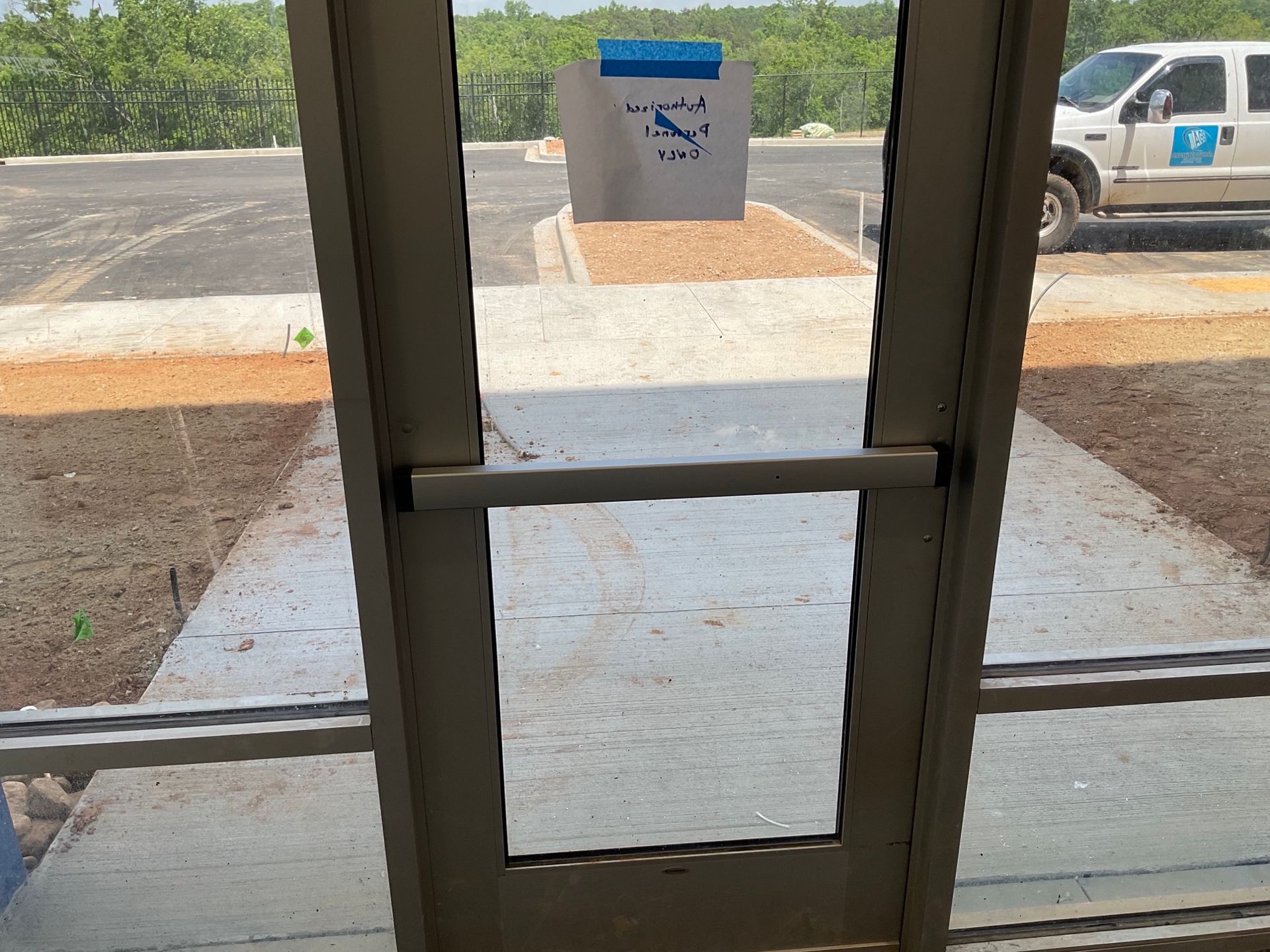 A white truck is parked in a parking lot behind a glass door