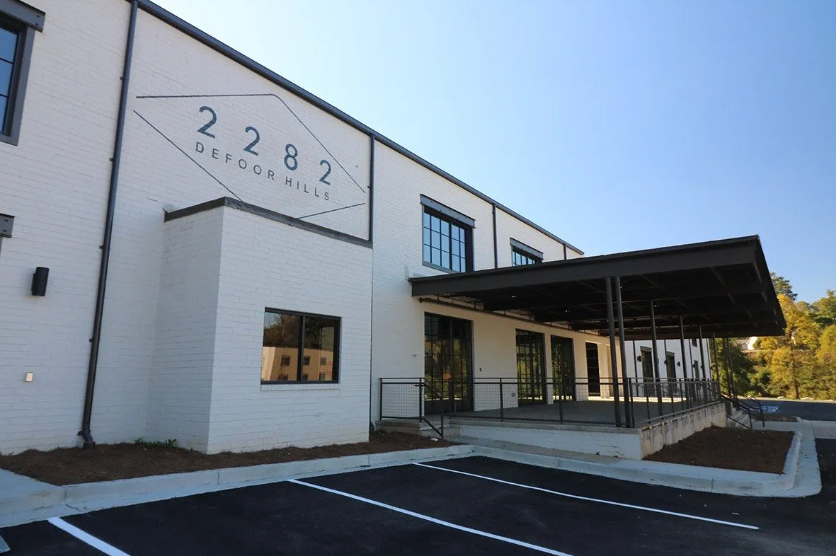 A large white building with a parking lot in front of it.