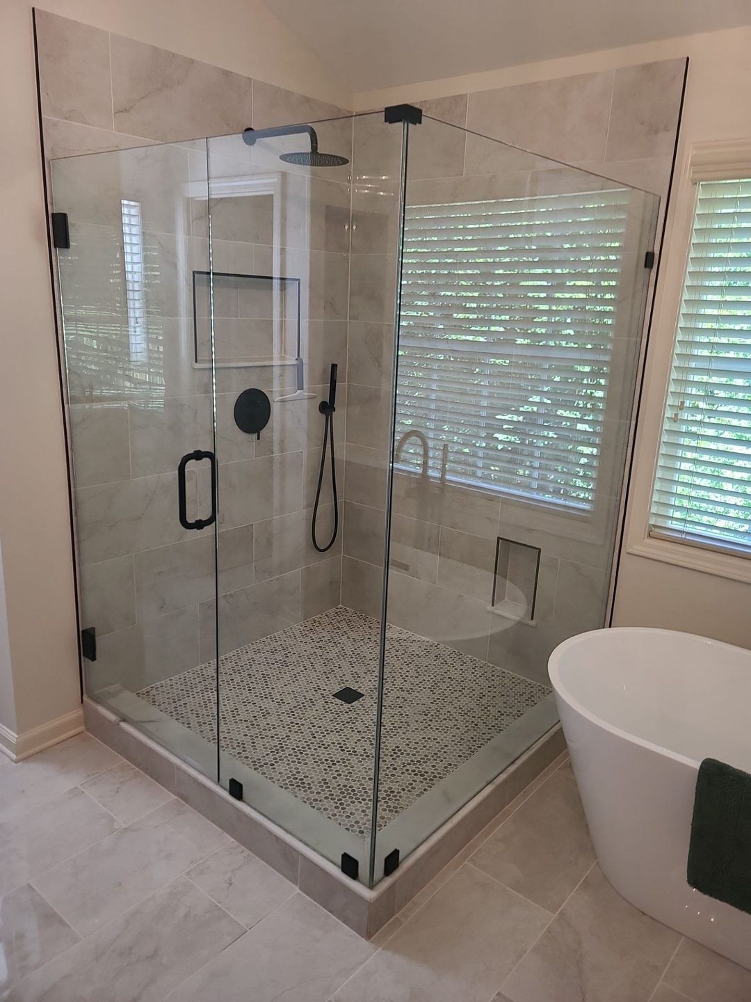 Frameless corner glass shower with clear glass and matte black hardware in a Newnan, GA bathroom