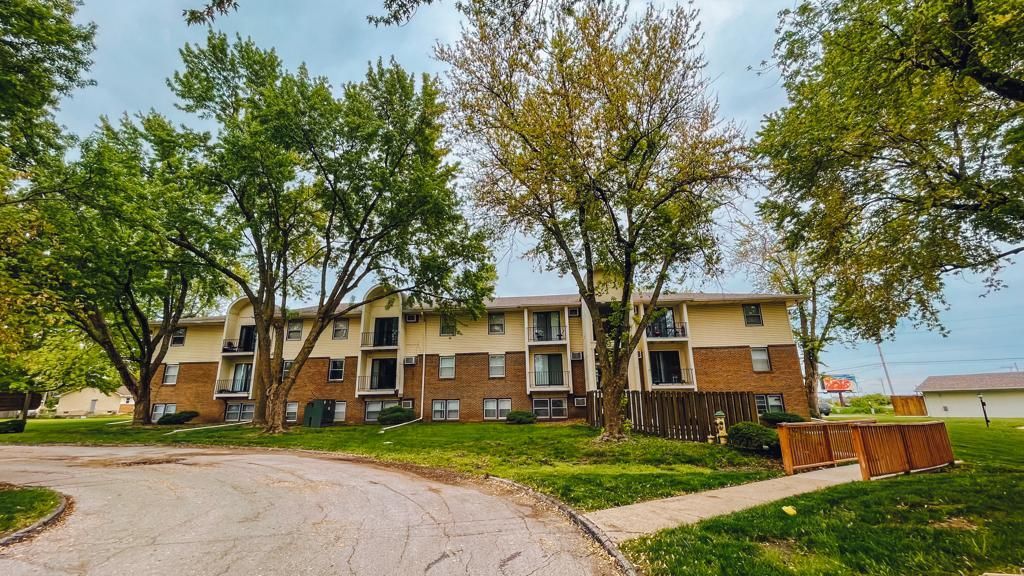 a large apartment building with a lot of trees in front of it .