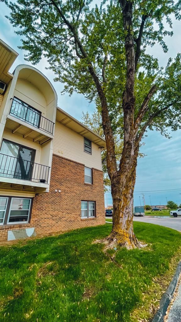 a large apartment building with a tree in front of it .