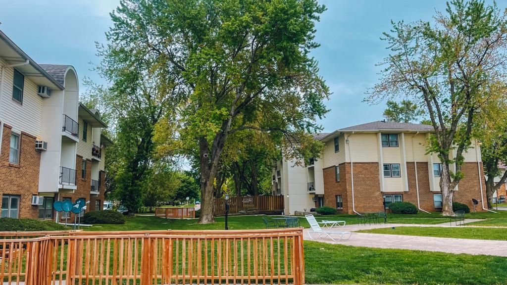 a row of apartment buildings with a wooden fence in front of them .