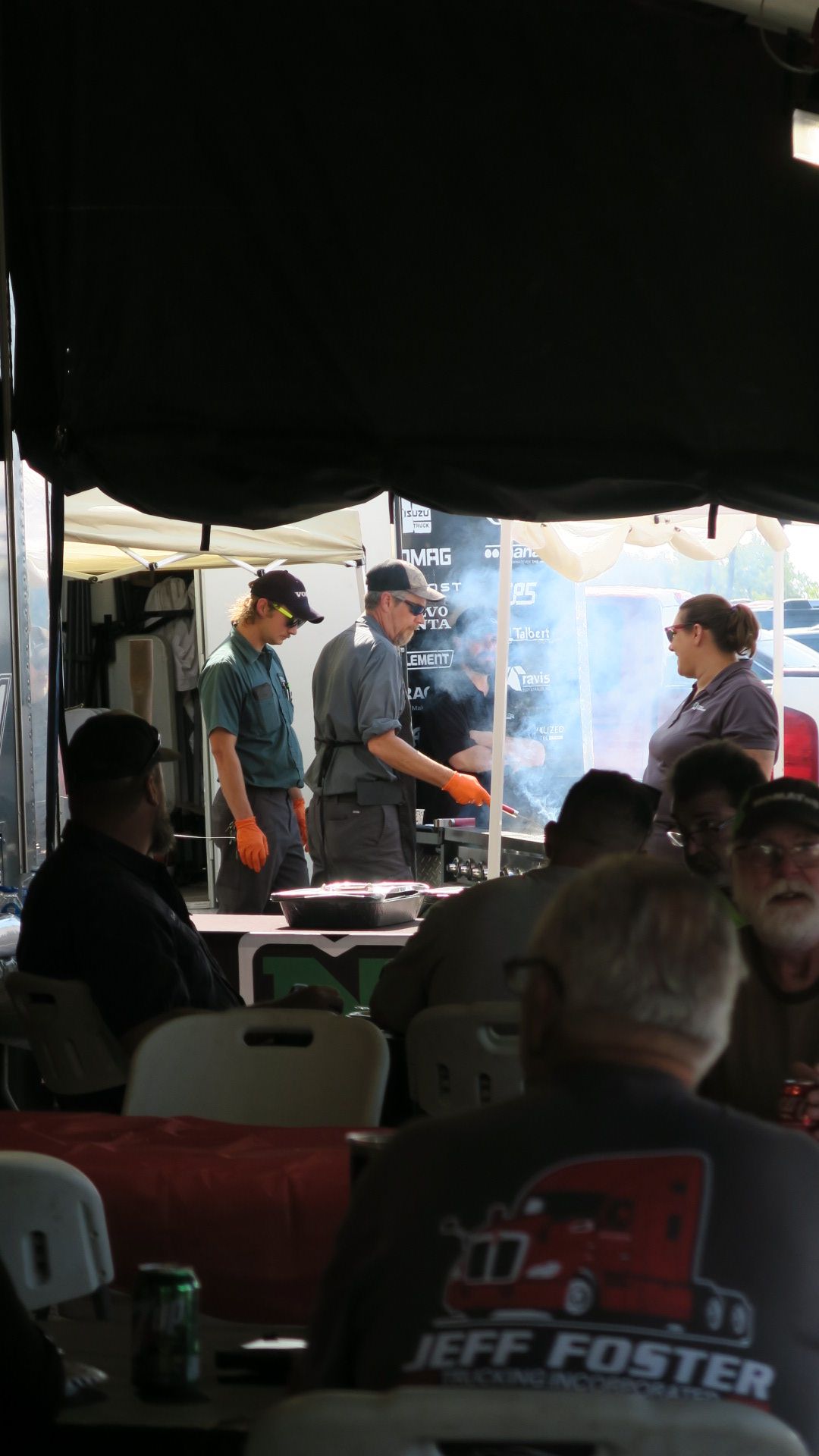 A man wearing a jeff foster shirt is sitting at a table
