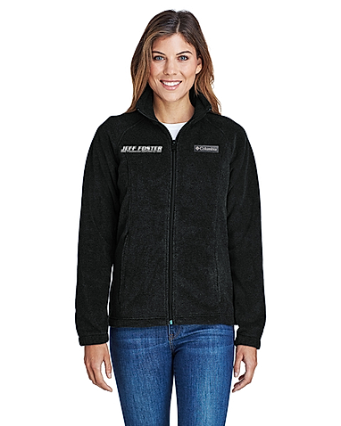 A woman is wearing a black fleece jacket and jeans.
