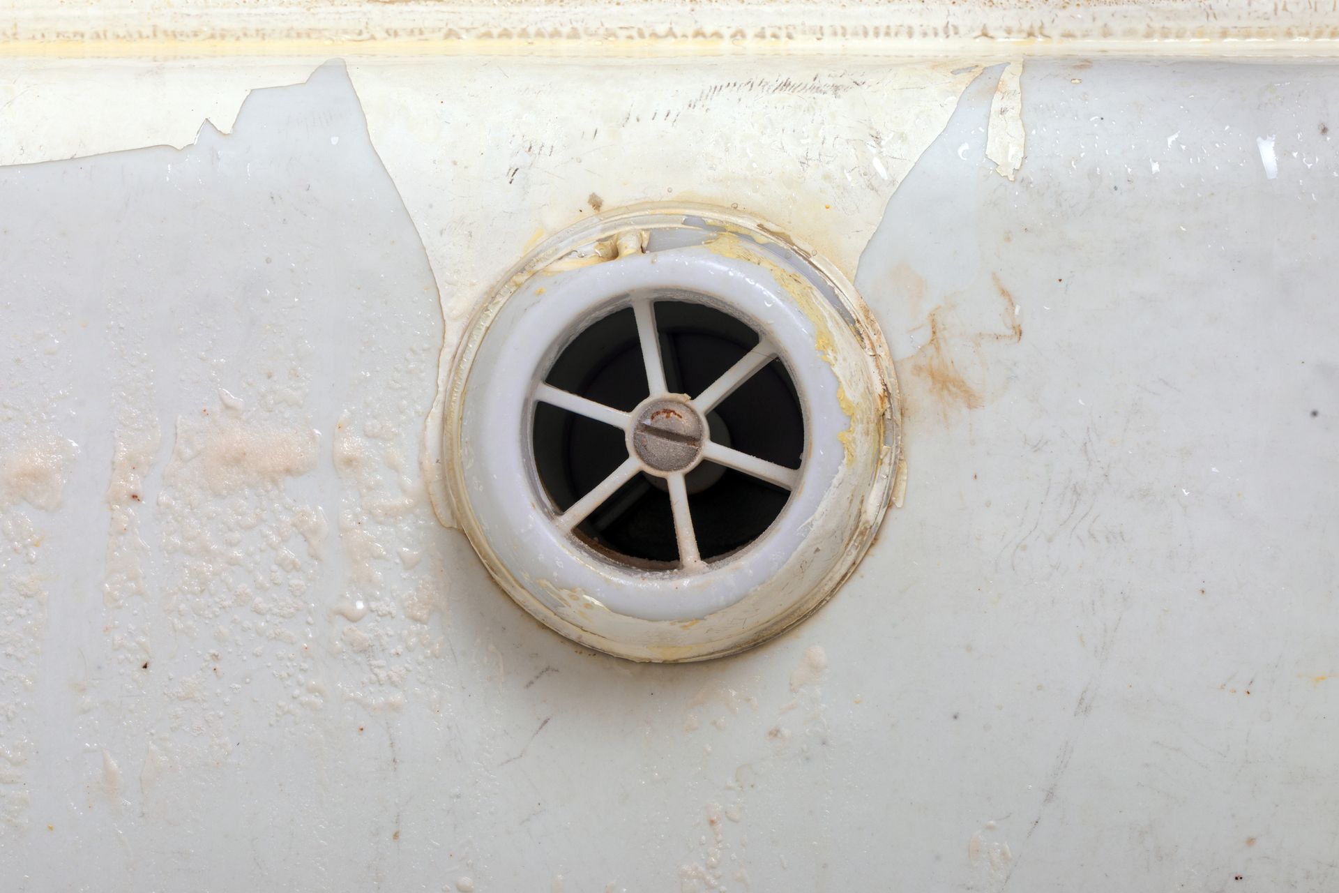 Round white vent with black grille on a stained off-white wall or panel. Round white vent with black grille on a stained off-white wall or panel.