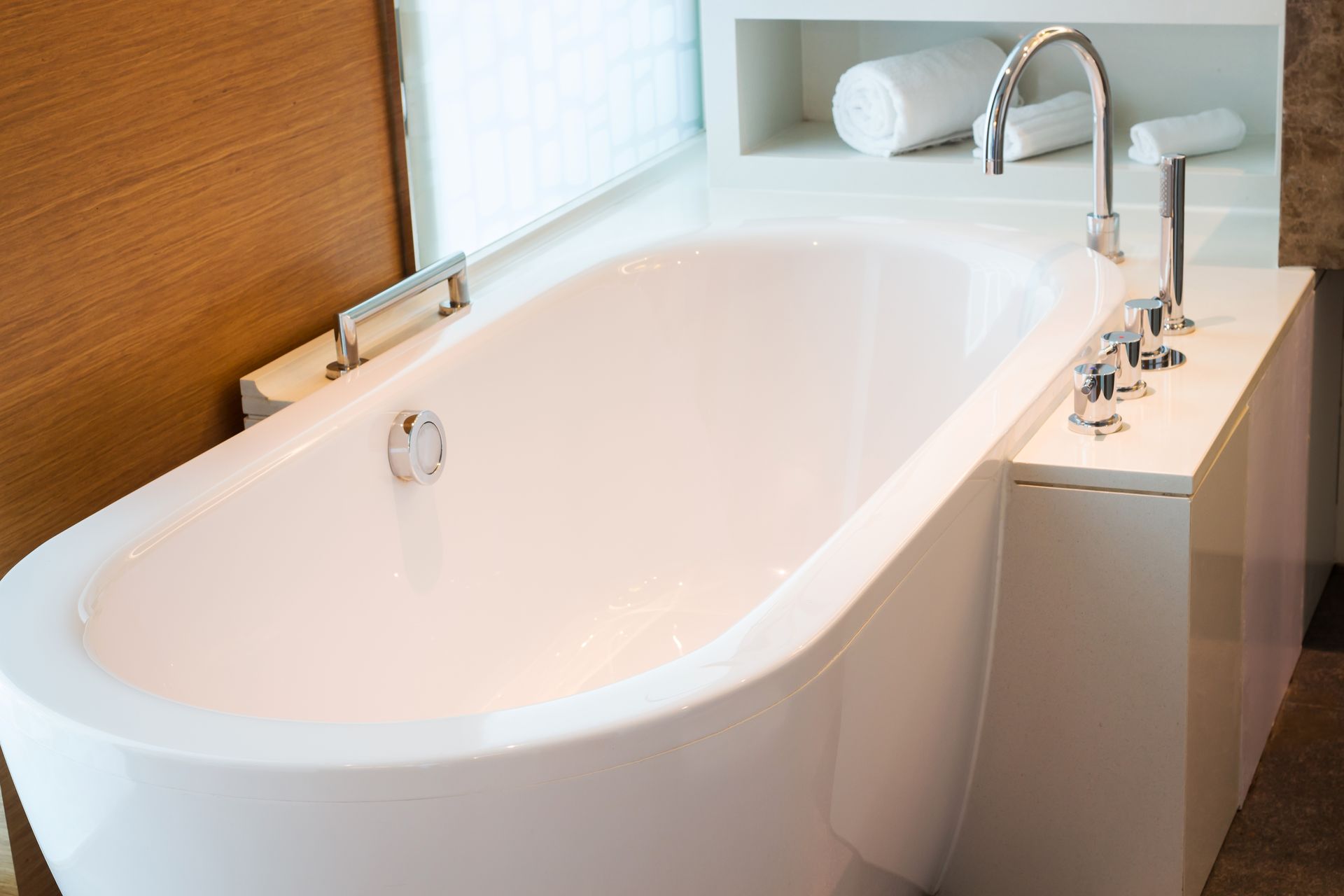 Bathroom interior in cozy colors with modern bathtub.