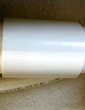 White PVC coupling installed on bathtub pipe after repairing a split hose connection. White PVC coupling installed on bathtub pipe after repairing a split hose connection.
