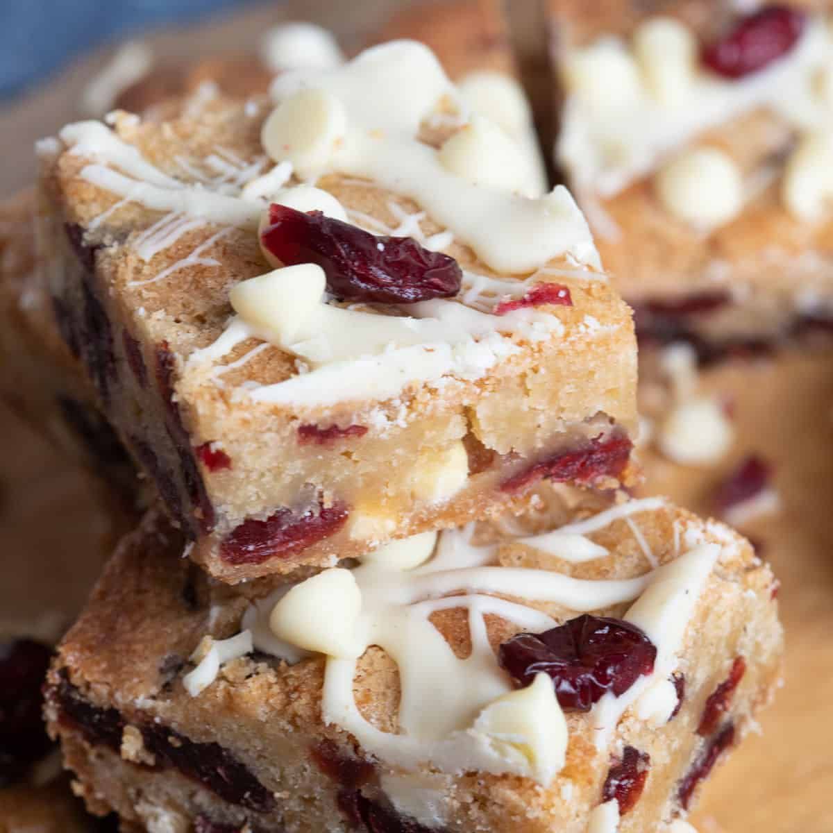 Gestapelde blondierepen, afgewerkt met een laagje witte chocolade, stukjes witte chocolade en gedroogde cranberry's.