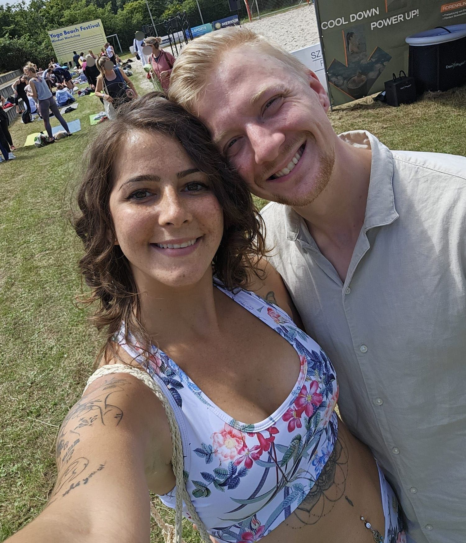Claudia und Cedric Bierbrauer Diaz lächeln auf einem Yoga-Festival in die Kamera.