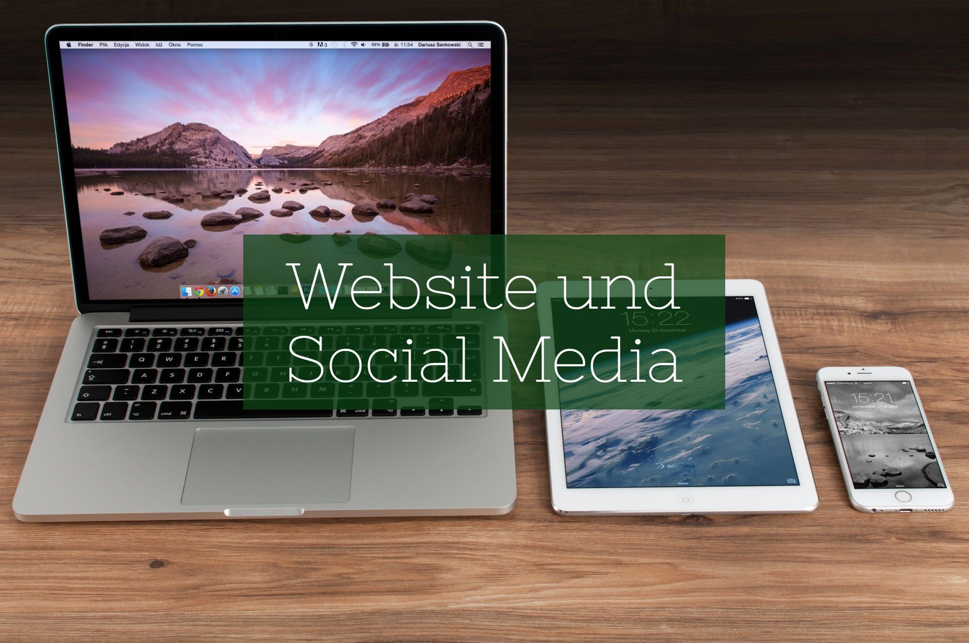 Ein Laptop, Tablet und Smartphone auf einem Tisch. Darauf befindet sich ein Textfeld, auf dem „Website und Social Media