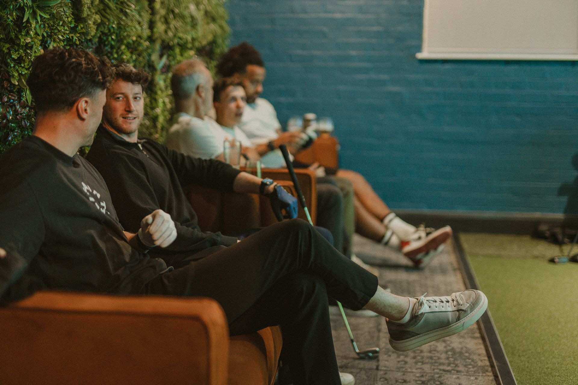 People sitting on a couch in the vip suite at SKRATCH Golf