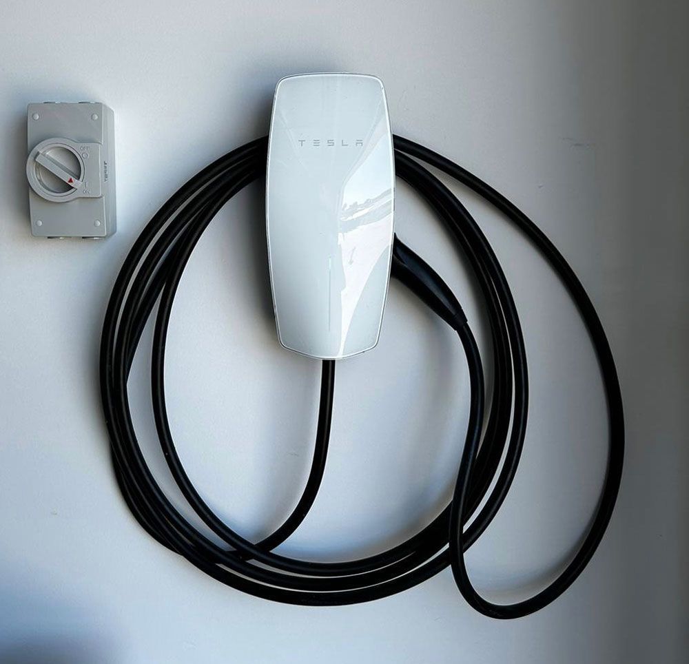 A Tesla Charging Station is Attached to a Wall — Ocean Air Electrical in Skennars Head, NSW