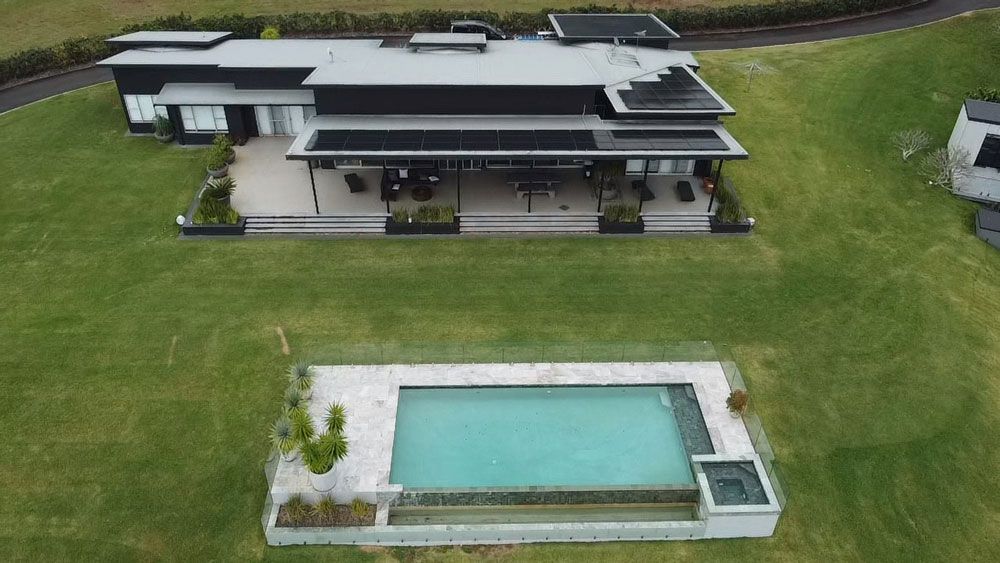 An Aerial View of a Large House With Solar Panels on the Roof — Ocean Air Electrical in Byron Bay, NSW