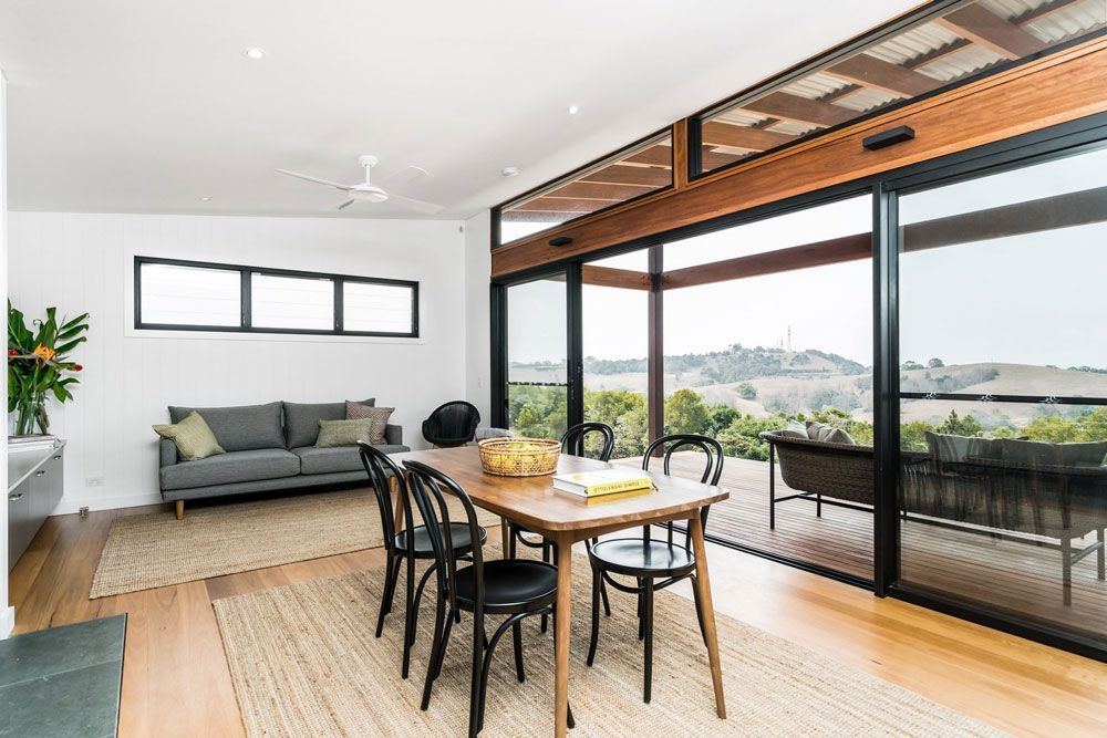 A Living Room With a Dining Table and Chairs and a Couch — Ocean Air Electrical in Bangalow, NSW