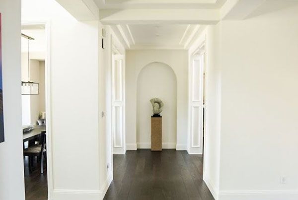A hallway with a statue on a pedestal in the middle