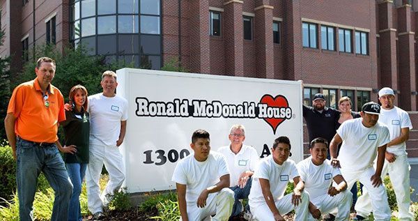 A group of people standing in front of a sign that says ronald mcdonald house