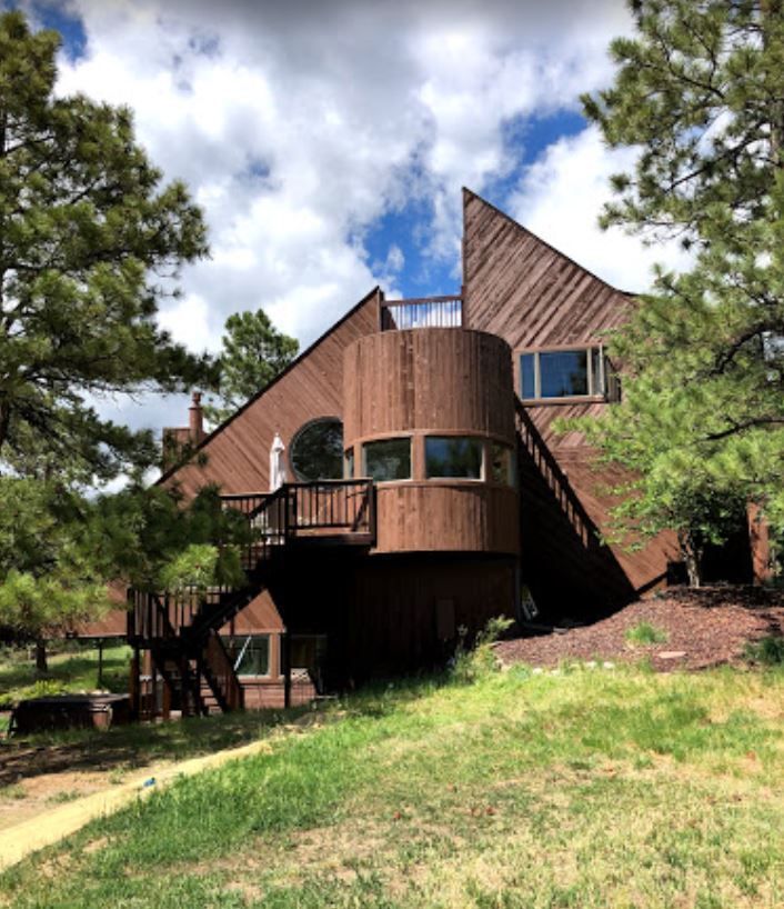 A large wooden house with stairs leading up to it