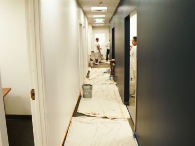A hallway is being painted in a building.