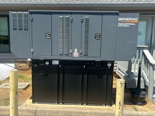 A generator is sitting in front of a house.