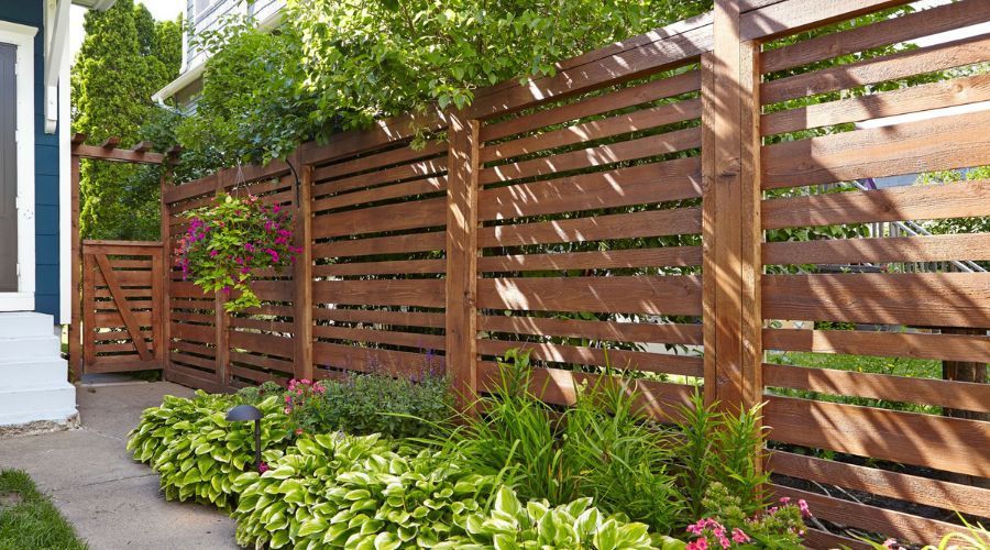 Modern horizontal wood privacy fence and gate designed to follow residential installation rules.