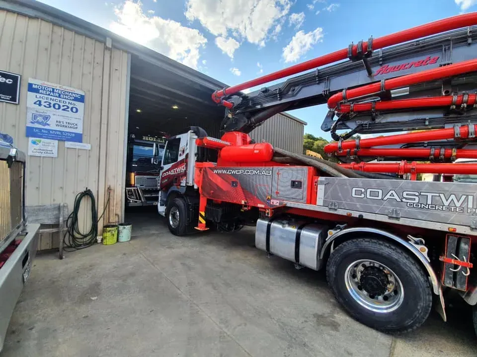 A Red Coastline Concrete Pump Truck Parked Outside a Garage — Mid North Coast Heavy Vehicle Repairs In Lake Cathie, NSW