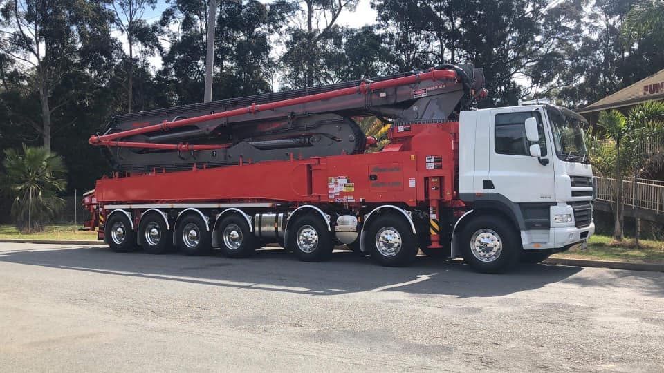 A Concrete Pump Truck Parked on an Asphalt Lot — Mid North Coast Heavy Vehicle Repairs In Laurieton, NSW