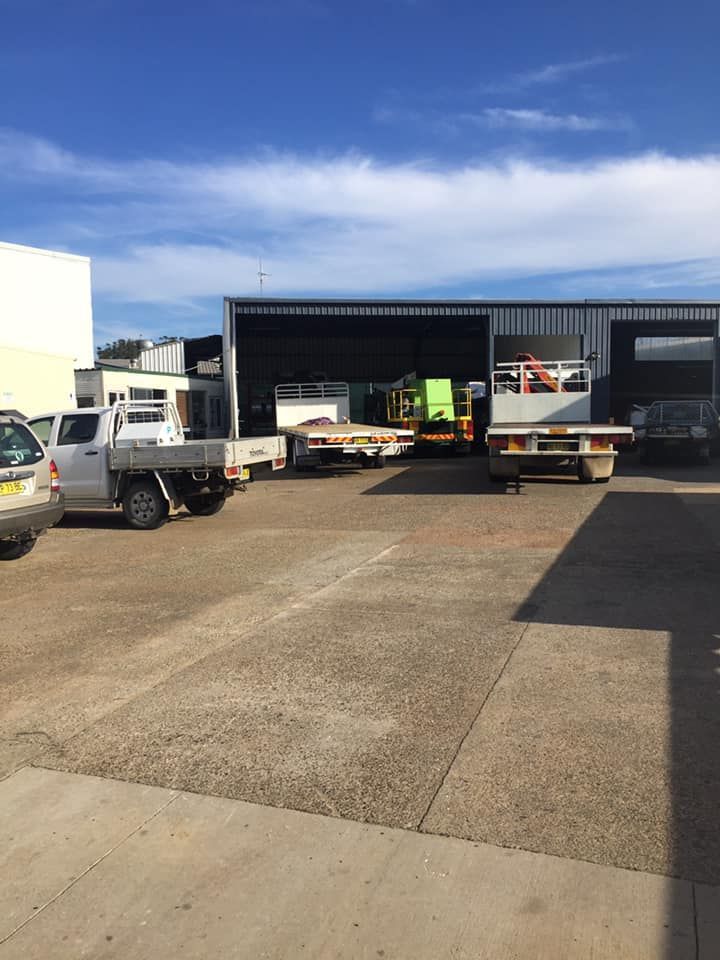 A Commercial Workshop Yard With Several Work Trucks Parked Outside — Mid North Coast Heavy Vehicle Repairs In Laurieton, NSW