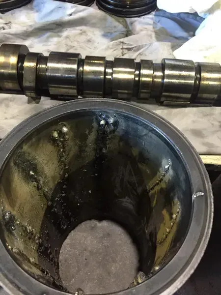 A Metal Camshaft Placed Above a Cylindrical Engine Component — Mid North Coast Heavy Vehicle Repairs In Wauchope, NSW