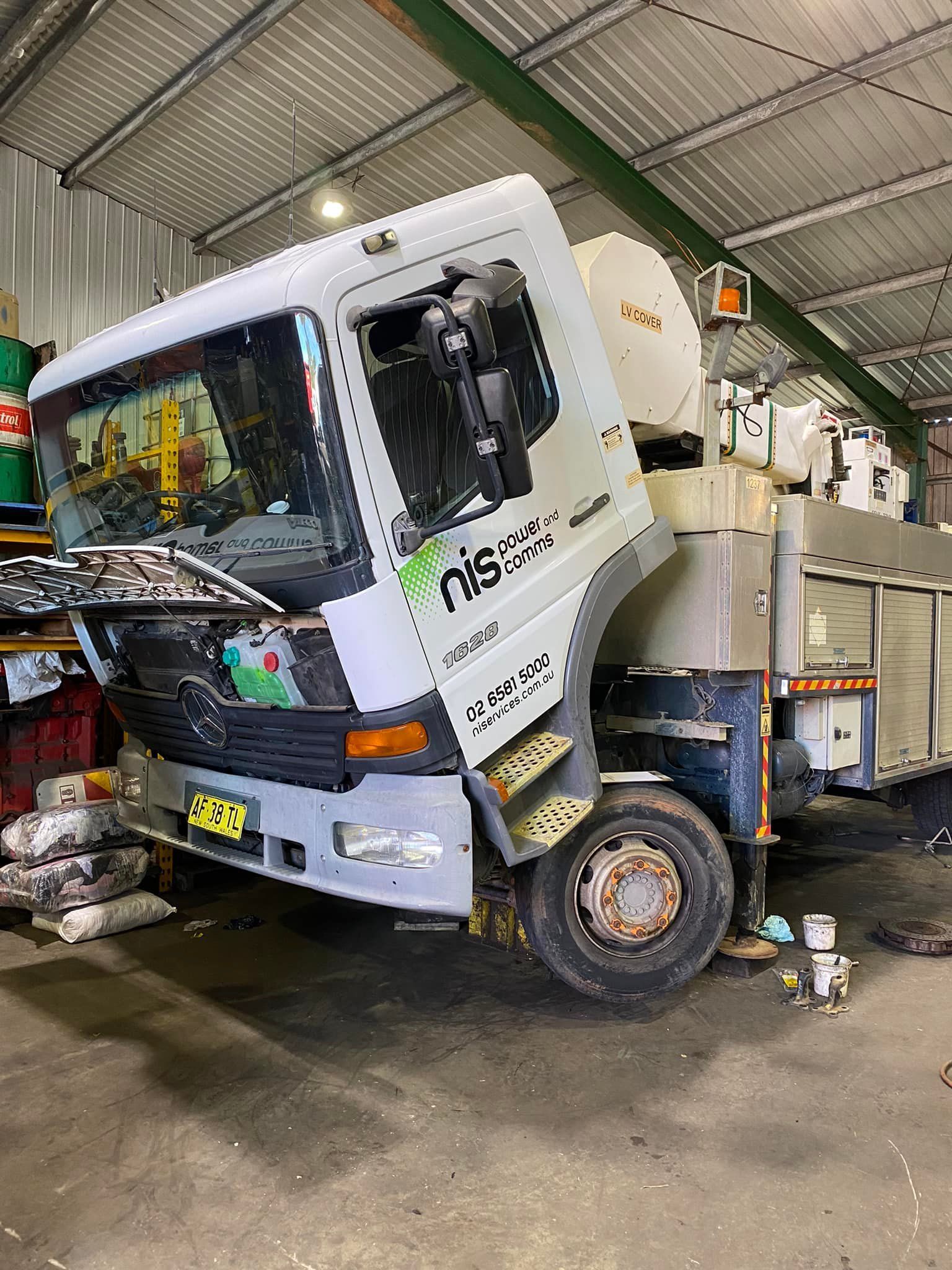 A White Nissan Cab-over Truck Parked Inside a Garage — Mid North Coast Heavy Vehicle Repairs In Bonny Hills, NSW