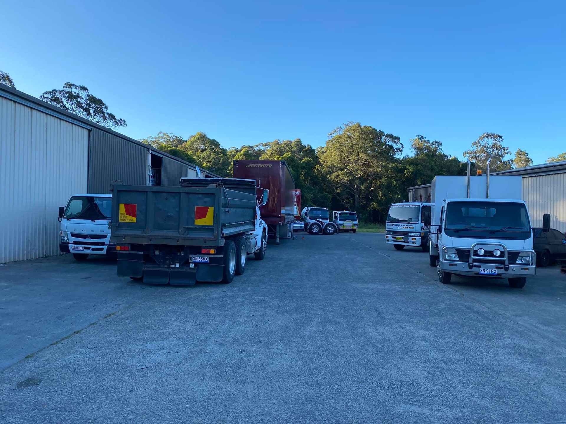 A Gravel Lot With Several Parked Work Trucks — Mid North Coast Heavy Vehicle Repairs In Wauchope, NSW