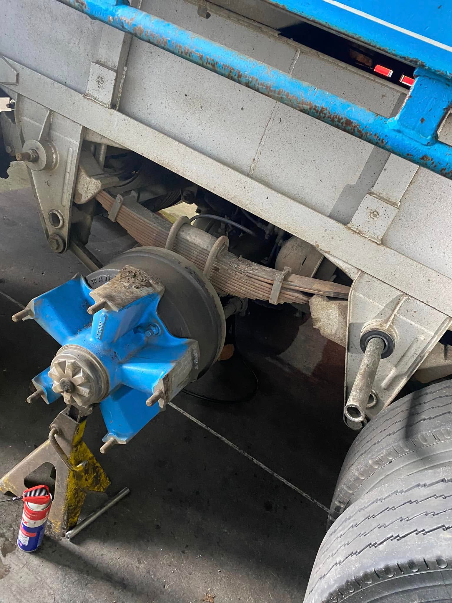 A Blue Wheel Hub and Leaf Spring Suspension on a Truck — Mid North Coast Heavy Vehicle Repairs In Kew, NSW