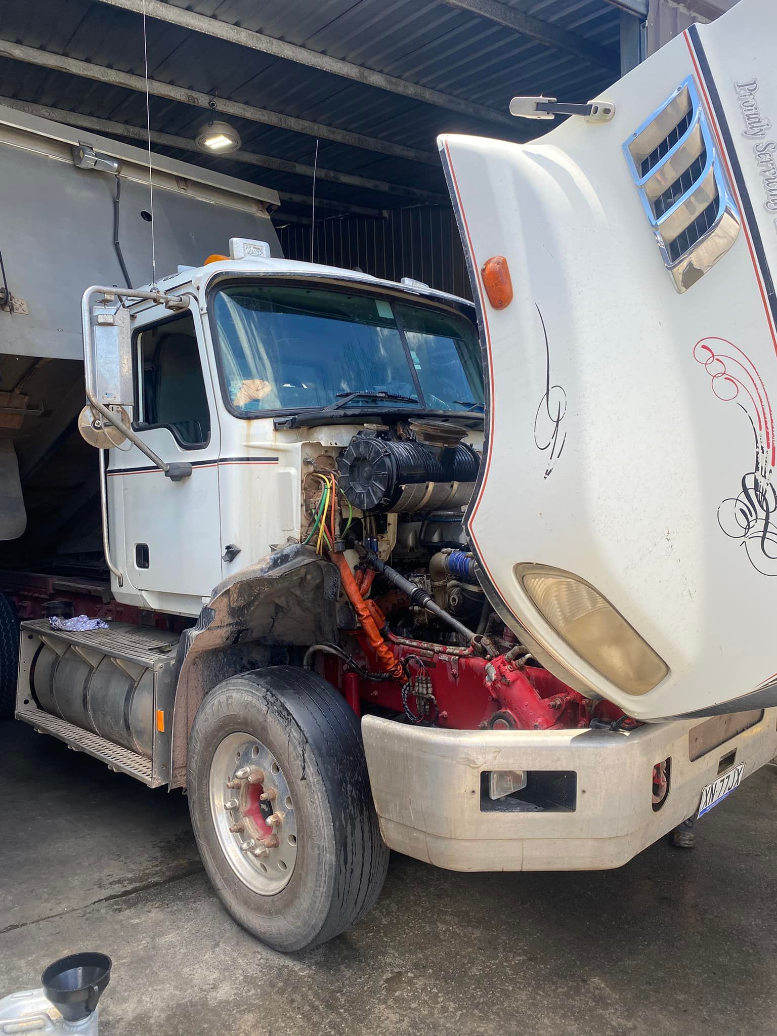 A White Semi-truck Parked Indoors With Its Hood Tilted Open — Mid North Coast Heavy Vehicle Repairs In Wauchope, NSW