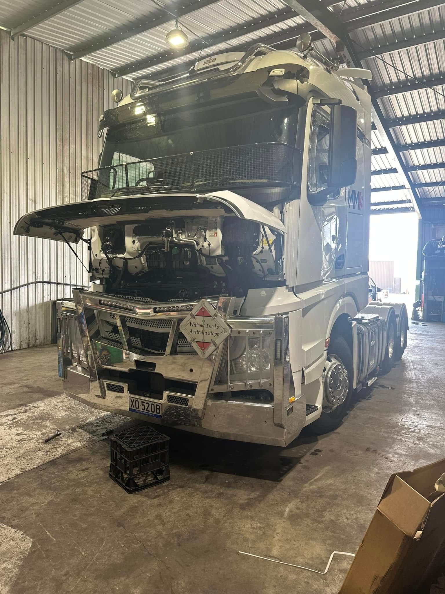 A White Semi-truck in an Indoor Service Bay With Its Hood Raised — Mid North Coast Heavy Vehicle Repairs In Wauchope, NSW