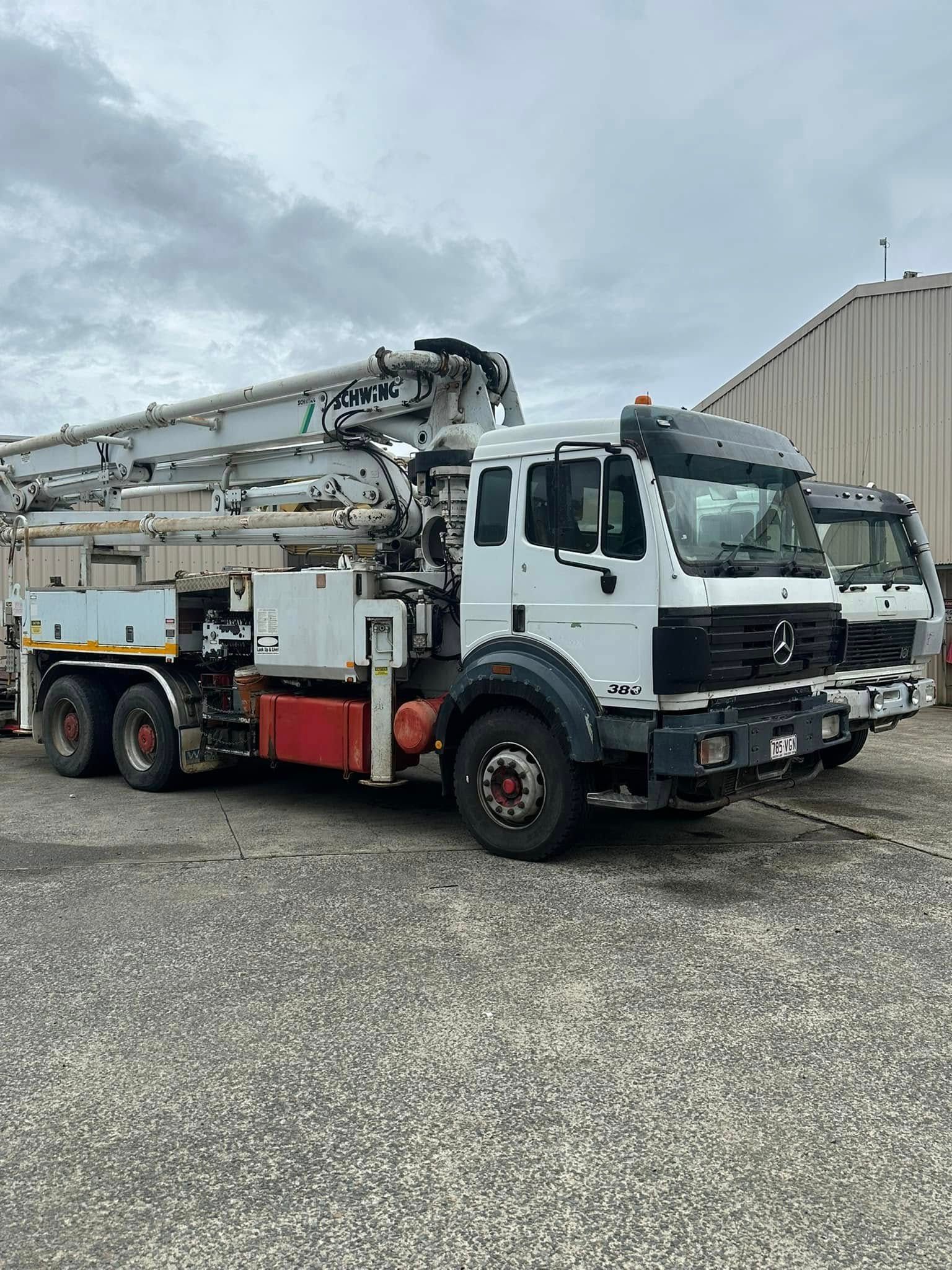 A White Concrete Pump Truck Parked on a Gravel Lot — Mid North Coast Heavy Vehicle Repairs In Wauchope, NSW