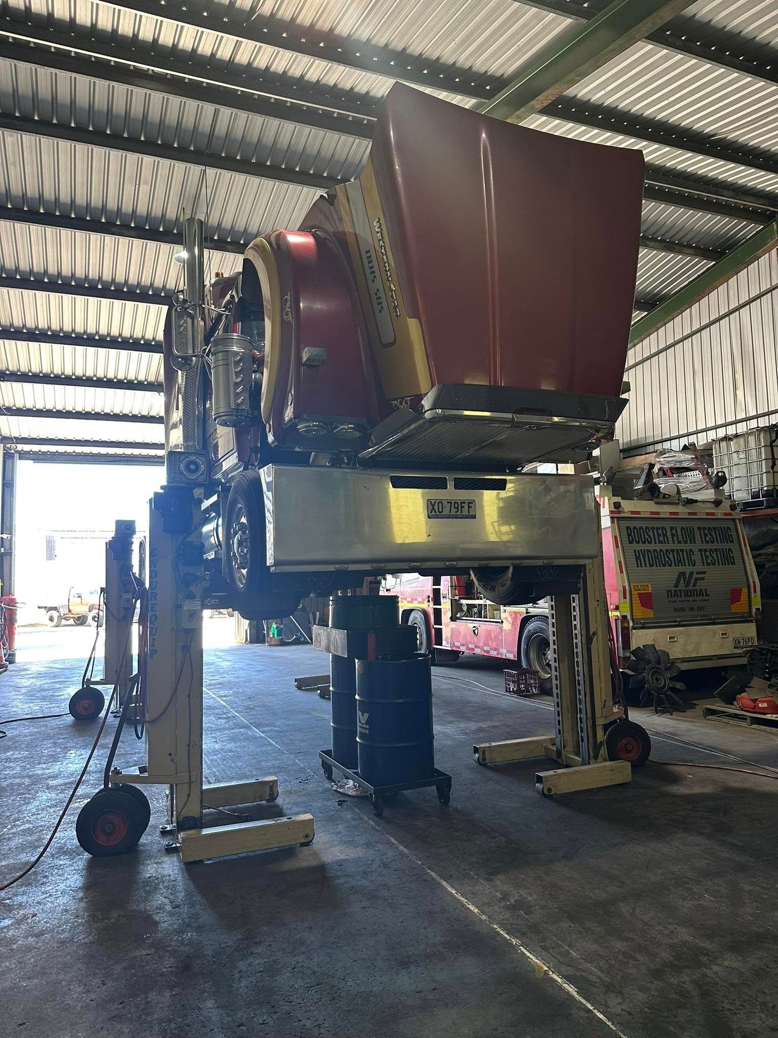 A Large, Maroon Truck Hood Lifted High — Mid North Coast Heavy Vehicle Repairs In Thrumster, NSW