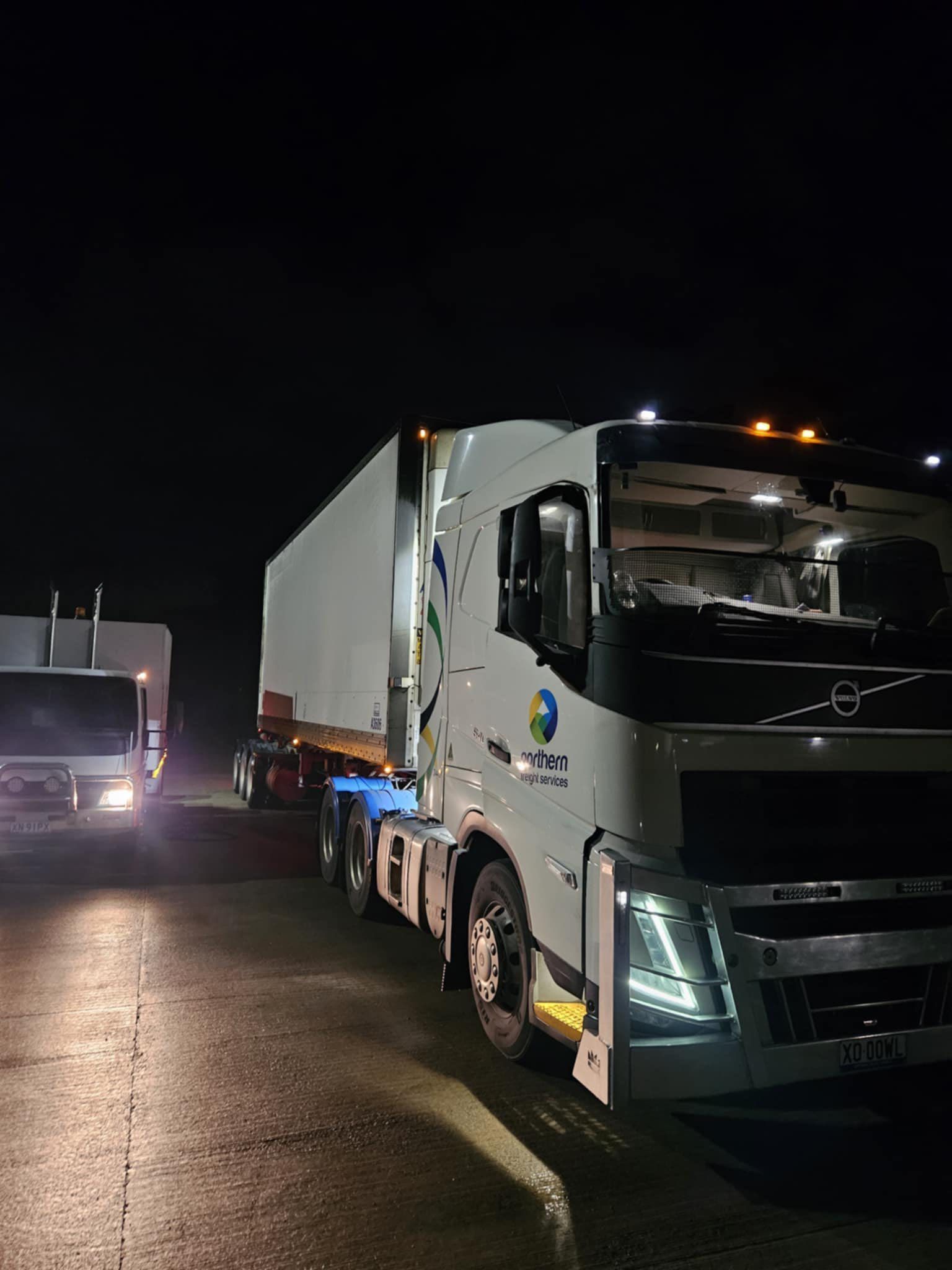 A White Volvo Semi-truck Parked on a Dark Road at Night — Mid North Coast Heavy Vehicle Repairs In Port Macquarie, NSW