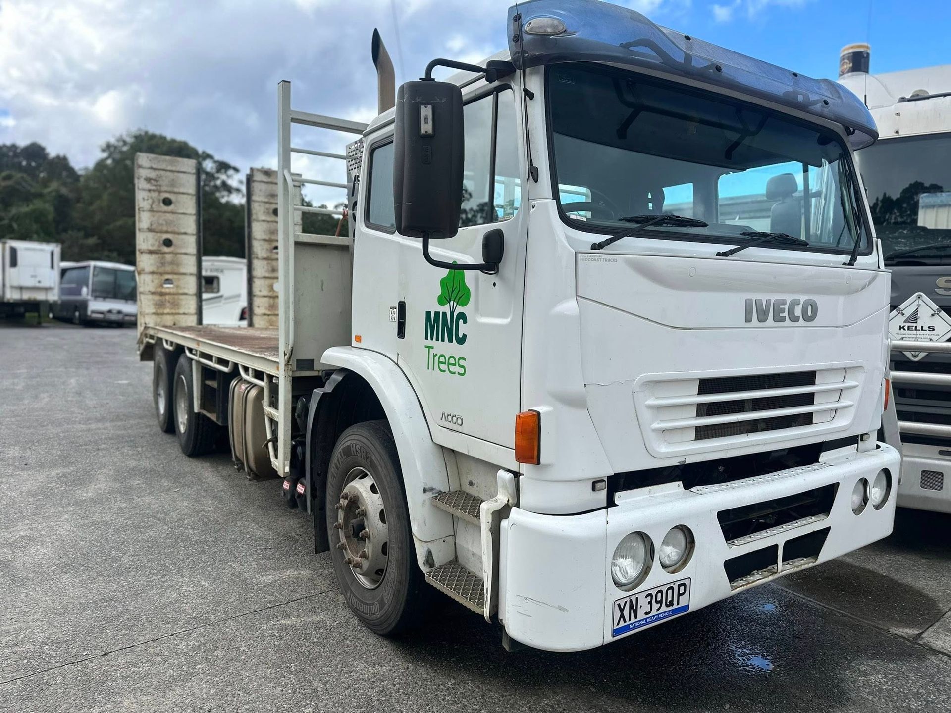 A White Iveco Flatbed Truck Parked on a Gravel Lot — Mid North Coast Heavy Vehicle Repairs In Wauchope, NSW