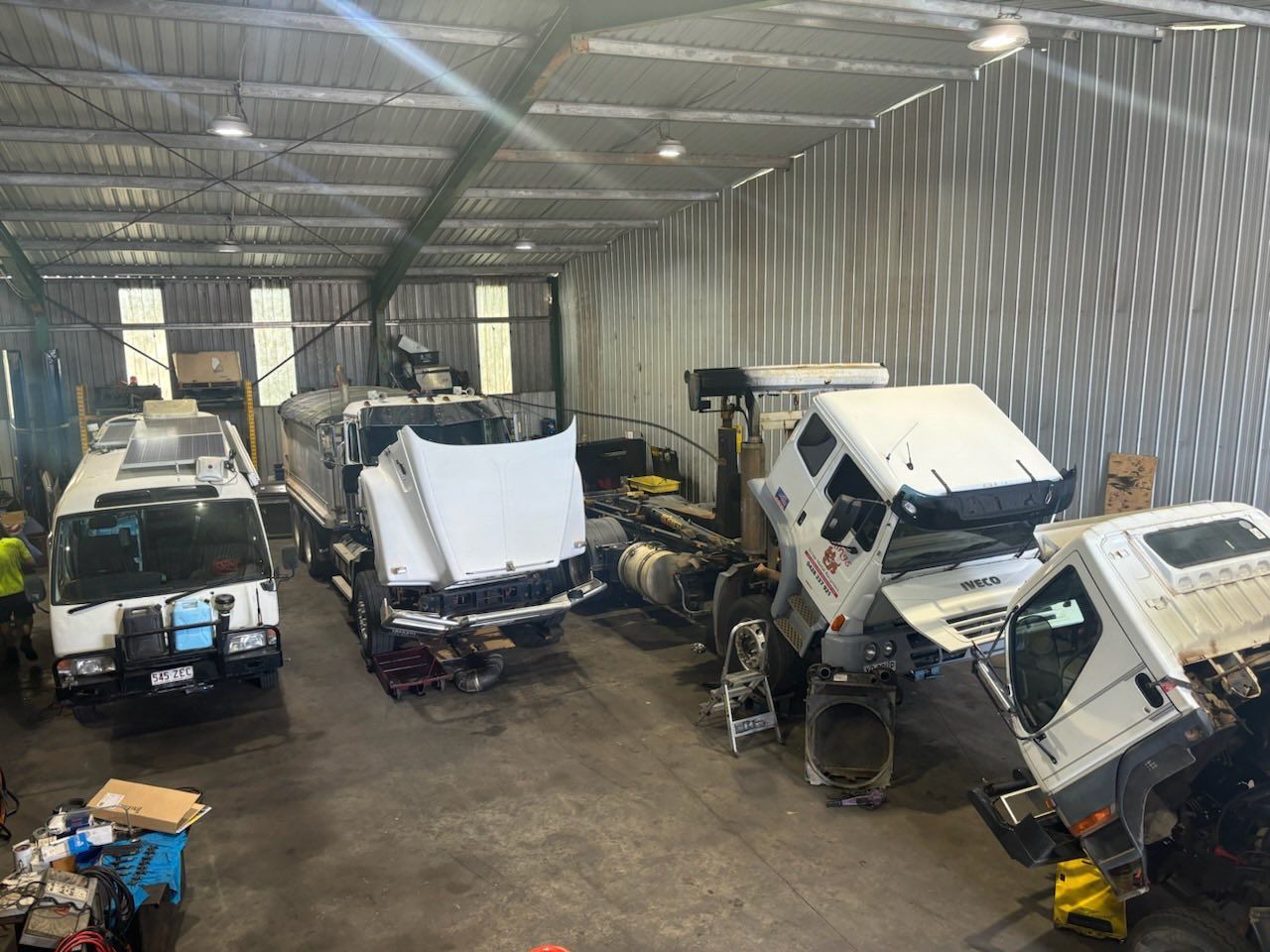 A Workshop Interior With Three White Commercial Trucks — Mid North Coast Heavy Vehicle Repairs In Port Macquarie, NSW