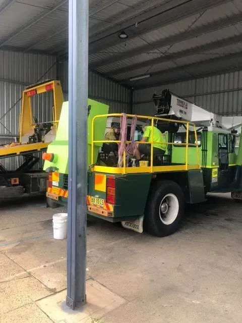 A Green and Yellow Bucket Truck Parked in a Large Warehouse — Mid North Coast Heavy Vehicle Repairs In Bonny Hills, NSW