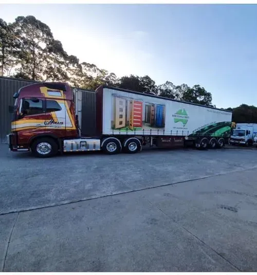 A Maroon and White Semi-trailer Truck Parked on a Paved Lot — Mid North Coast Heavy Vehicle Repairs In Bonny Hills, NSW