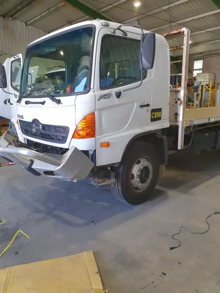 A White Hino Truck With a Damaged, Detached Front Bumper — Mid North Coast Heavy Vehicle Repairs In Wauchope, NSW