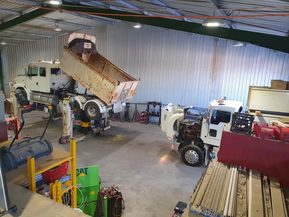 A Warehouse With Two Heavy-duty Trucks — Mid North Coast Heavy Vehicle Repairs In Lake Cathie, NSW